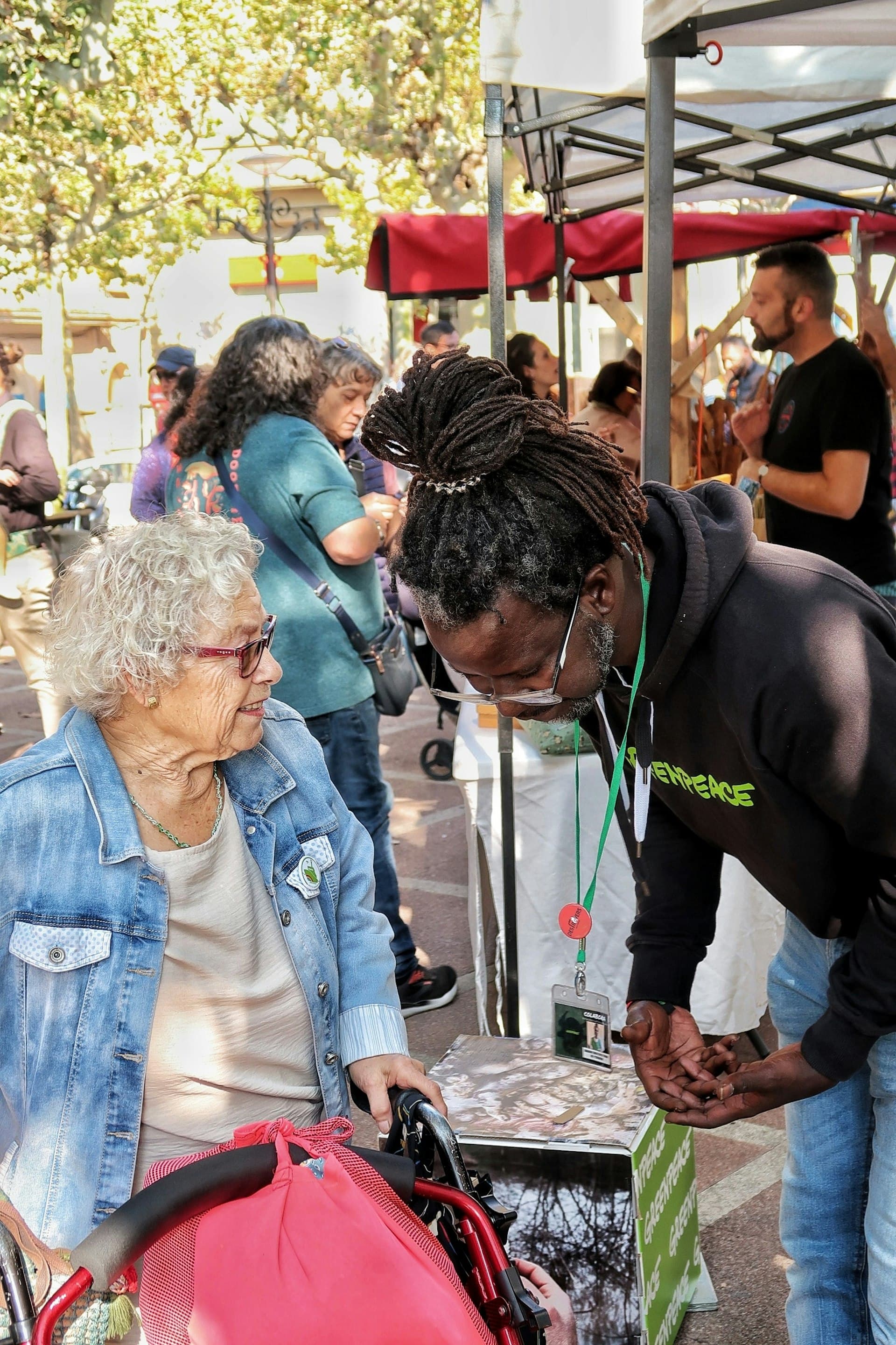 Elderly woman in wheelchair talking with a carer